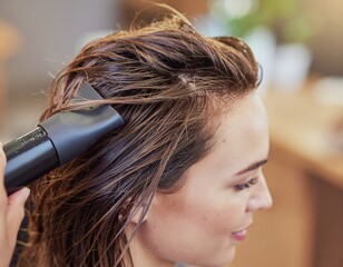 Fototapeta premium Hair care routine Expert hairstylist blow-drying a woman's wet hair in a salon, creating a fresh look
