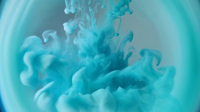 Mesmerizing turquoise ink cloud swirls and dissolves in clear liquid, creating abstract, ethereal patterns and shapes