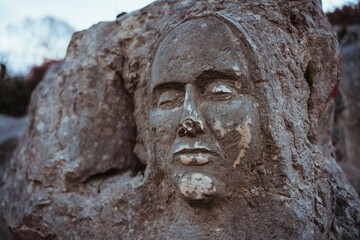 Obraz premium portrait of a human face carved on natural rock. Outdoor trekking in a natural forest environment. Shot in the Lepini Mountains, Lazio, Italy.