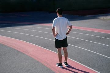 Young man preparing for a run on an outdoor athletics track. unrecognizable person