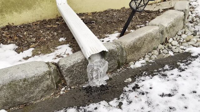 ice at the bottom of the gutter on a cold January day