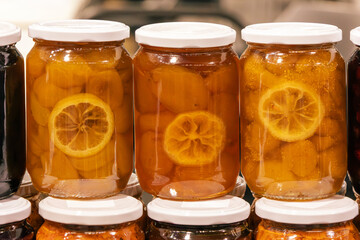 Sweet homemade fruit chutney jams and preserves inside glass jars sold outside on market