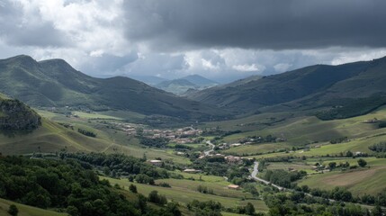 Rolling green mountainsides cradle a small settlement nestled in a valley under dramatic clouds