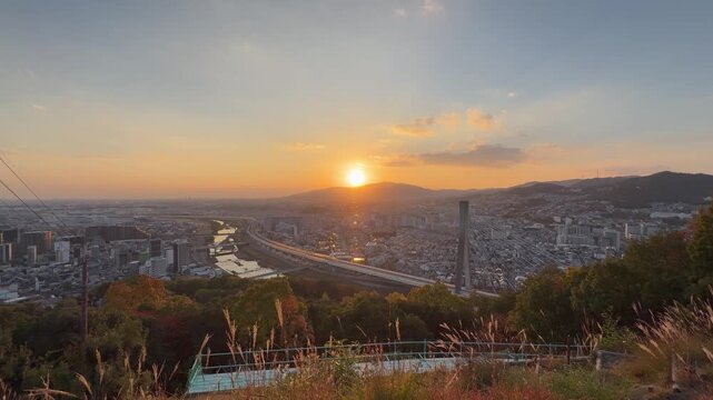 Panoramic Aerial View of a Vibrant Golden Sunset Over Ikeda City and the Shin-Inagawa Bridge in Osaka Japan
