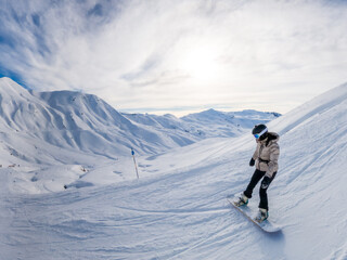 Snowboarder riding down mountain slope in winter