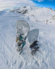 Snowboards standing on mountain peak overlooking ski resort