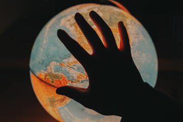  Geography study.Travel around the globe.black hand silhouette on globe.China and India on the globe and silhouette of a hand. Migration and politics concept
