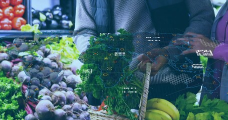 Selecting shoppers holding woven basket choosing leafy greens at produce stall, digital map overlay