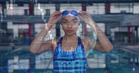 Adjusting swimmer securing goggles at covered pool in blue swimsuit, white cap, market overlay