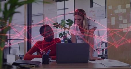 Working two coworkers reviewing laptop at office, red sweater and light blouse, red network overlay
