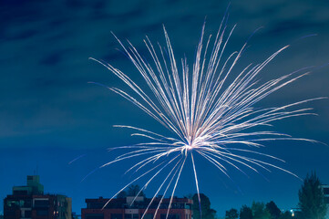A massive radial explosion of white fireworks in the night sky