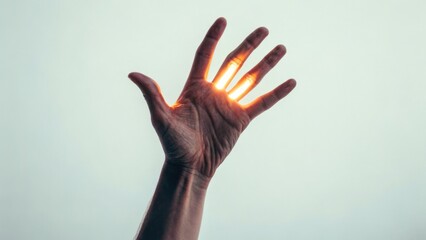 Hand bathed in golden light, fingers reaching upwards