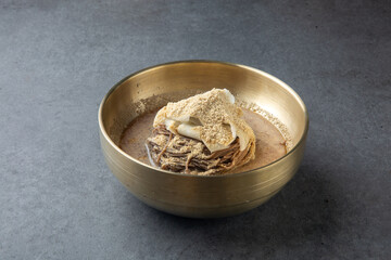 Korean Cold Soy Milk Noodles in Brass Bowl on Stone Background 놋그릇에 담긴 한국식 콩국수