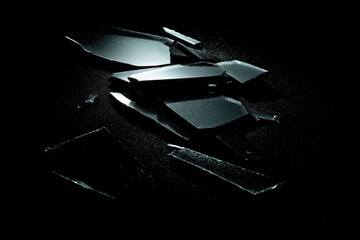 Obsidian shards with sharp edges reflect light on dark background, showcasing volcanic glass texture and mysterious atmosphere in dramatic composition