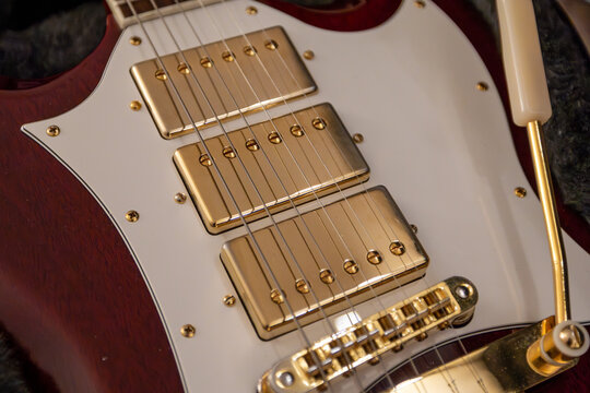 Electric guitar pickups with vibrola bridge, detailed close-up of strings and hardware - Powered by Adobe