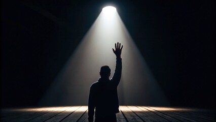 Silhouette Raising Hand Under Stage Spotlight