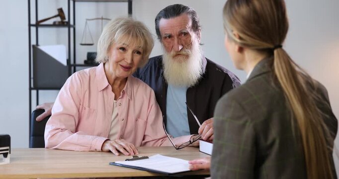 Notary consulting senior couple about Last Will and Testament in office