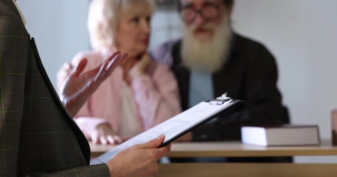 Notary consulting senior couple about Last Will and Testament in office, closeup