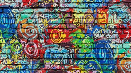 Obraz premium Vibrant graffiti-covered brick wall: a chaotic symphony of color and urban artistry