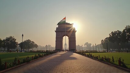 Sunrise view of India Gate monument with clear sky and surrounding greenery.