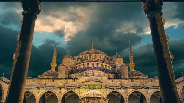 Historic Sultan Ahmed Mosque (Blue Mosque) under dramatic cloudy sky in Istanbul.