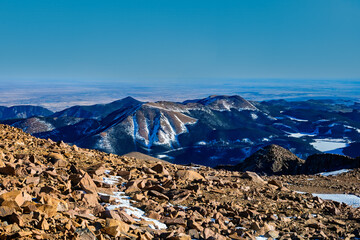 2024-12-21 A VIEW OF SNOW CAPPED MOUNTAINS AND ROCKY LANDSCAPE FROM PIKES PEAK IN COLORADO WITH A BLUE SKY