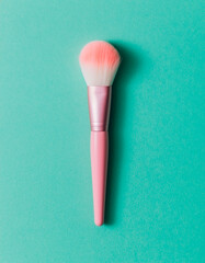 Single Pink Makeup Brush on Teal Green Background, Minimalist Beauty Tool Flat Lay, Top View