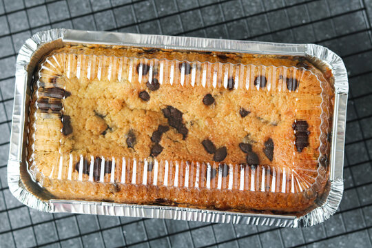 A whole brookie loaf in a packaging. A hybrid of fudgy chocolate brownie and chocolate chip cookie layers with a rich texture.