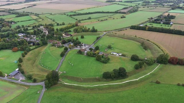 Avebury, Wiltshire, England. Aerial of village and huge prehistoric megalithic stone circle standing stones and henge complex. View to NW. Video static