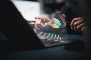 Analyzing Business Data on Laptop with Magnifying Glass