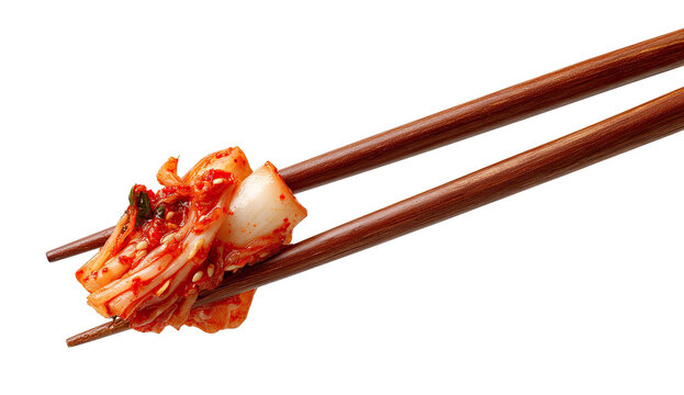 Spicy kimchi held in wooden chopsticks, against a stark black background