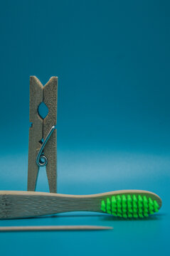 gancho de ropa de madera y cepillo de dientes de madera en fondo azul