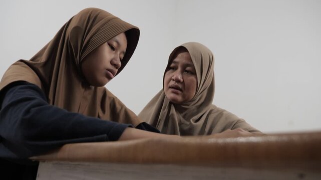 Muslim mother trying to persuade and calm her angry, disappointed and stubborn teenage daughter
