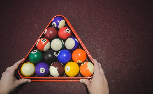 manos organizando las bolas de billar