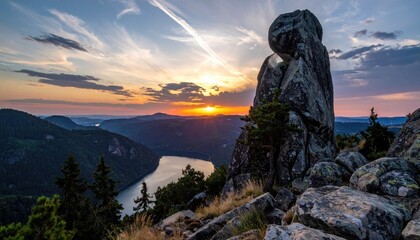Dramatic sunset over mountains and a lake with stone formations