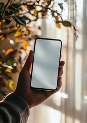Hand Holding Smartphone with Blank Screen and Bright Background