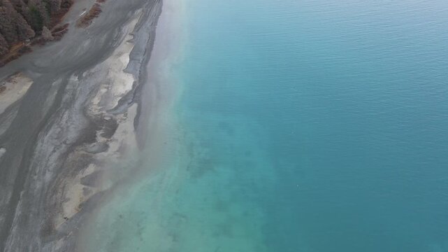 Top view aerial shot of turquoise Lake Tekapo and mountains in South Island, New Zealand

