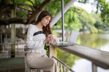 Young woman checking time while working outdoors