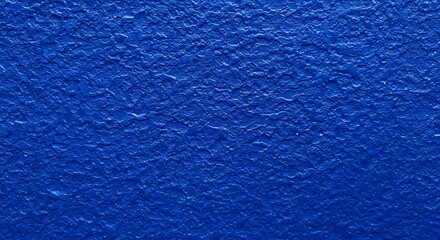 Closeup of textured blue painted wall surface with rough finish