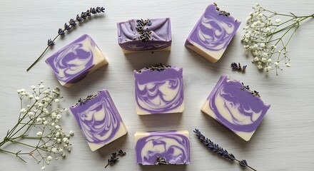 Purple and white marbled soap bars arranged on a wooden surface with lavender and baby's breath