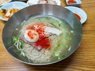 Refreshing Korean summer delicacy, Mul-naengmyeon. Cold buckwheat noodles topped with red chili powder and scallions, a healthy and savory oriental meal.
