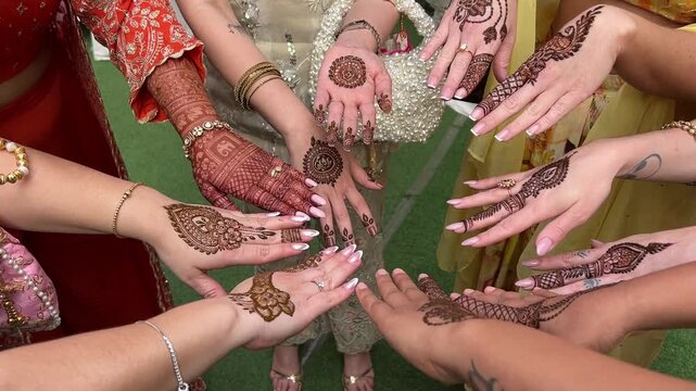 Girls showing their hands with mehendi designs in a wedding in India 