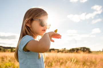 Curious Child Watching Butterfly in Summer Field

