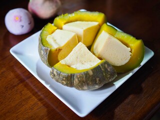 Egg custard steamed in pumpkin is served on a plate. This Thai dessert I made myself and it's very delicious.