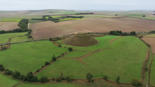 Silbury Hill prehistoric man made chalk and clay mound near Avebury stone circle henge, England. 39m high. Earliest dates from 2400BC. View from NE. Video fly in down