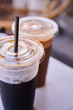Traditional Nanyang kopi-o (black coffee) and coffee with milk served in plastic takeaway cups at a kopitiam in Malaysia.