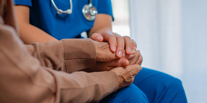 With empathetic and caring attention, professional nurses hold the hands of elderly patients to comfort and encourage them, while also offering advice on healthcare.