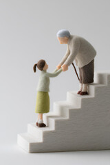 階段を上る高齢者を優しく支える少女の思いやり（フェルト・3D）まみおデザイン福祉シリーズ
