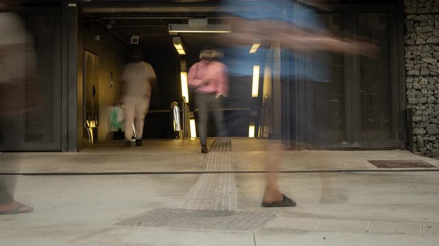 blurred rush of people entering and exiting metro station in barcelona