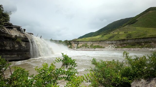 Waterfall entering wide valley landscape